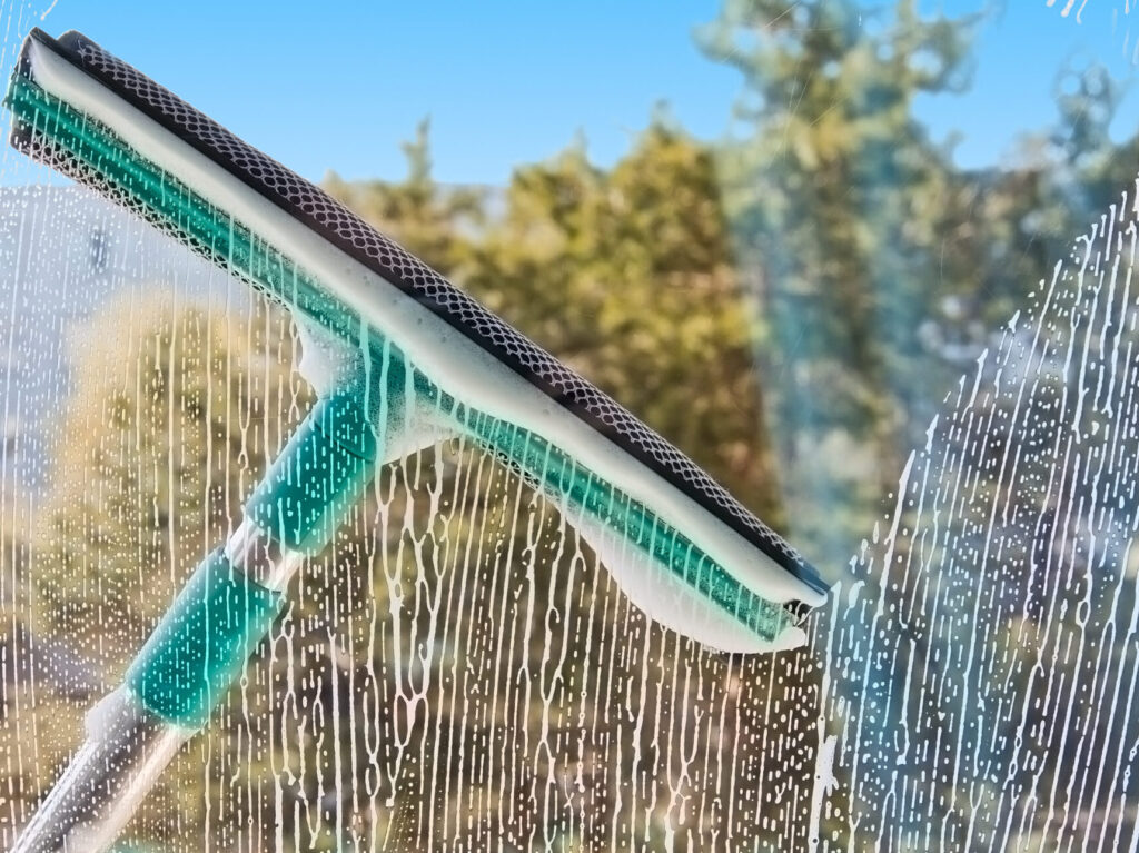 window cleaning with soap and squeegee