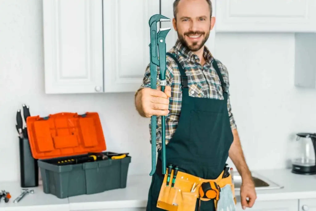 A smiling handyman showing a monkey wrench