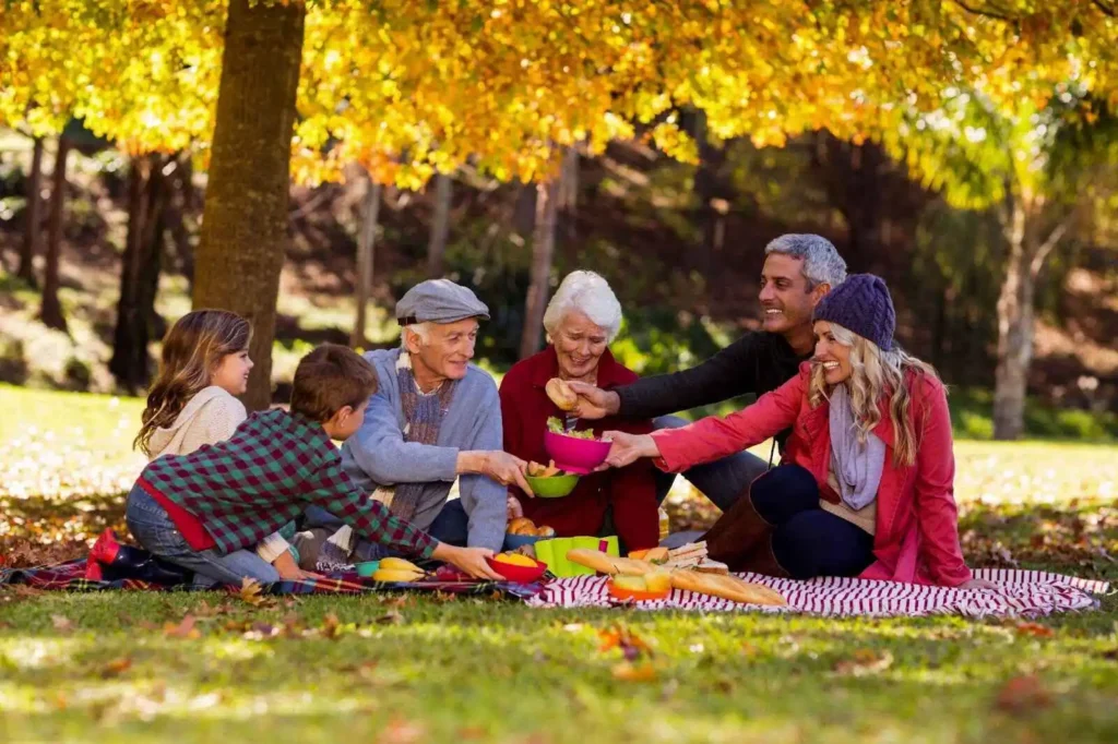 Family having breakfast outdoors under a tree
