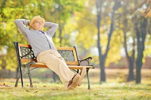 Man in garden sitting in a bench