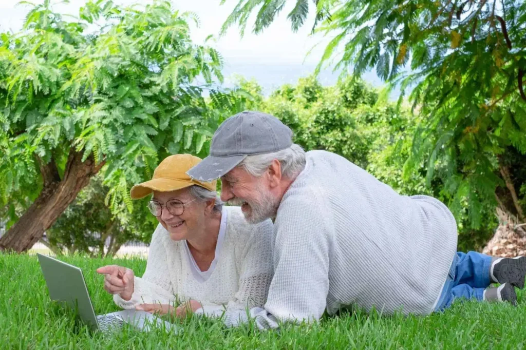Senior couple happily using laptop together