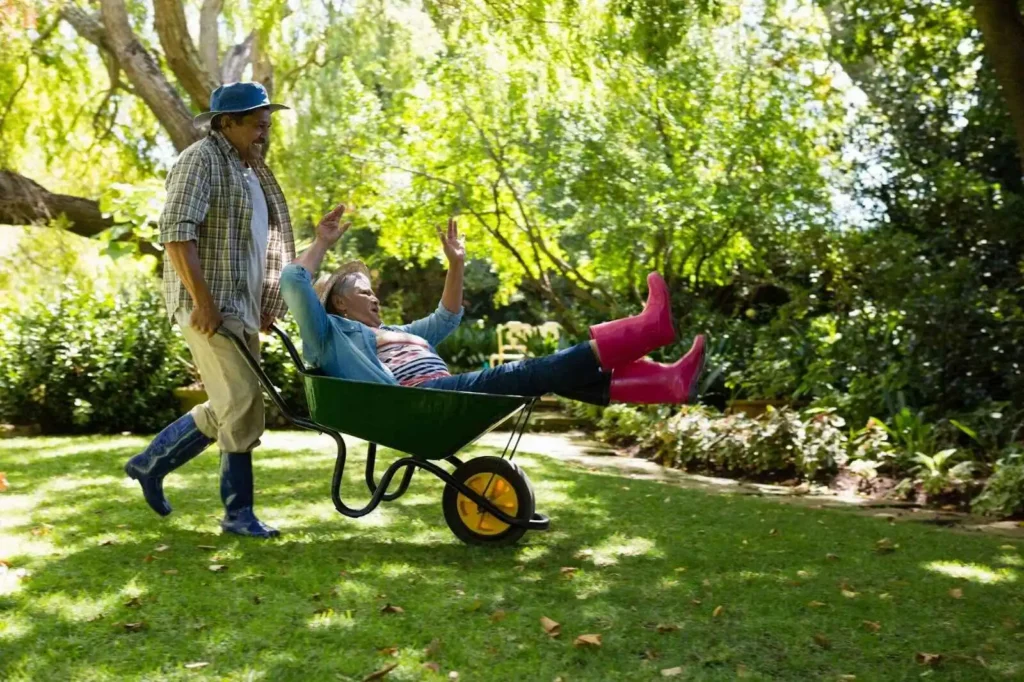 showing Senior man giving woman ride in wheelbarrow