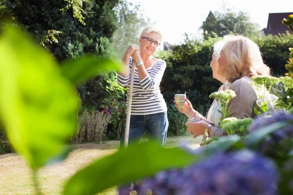 Three women in garden talking each other