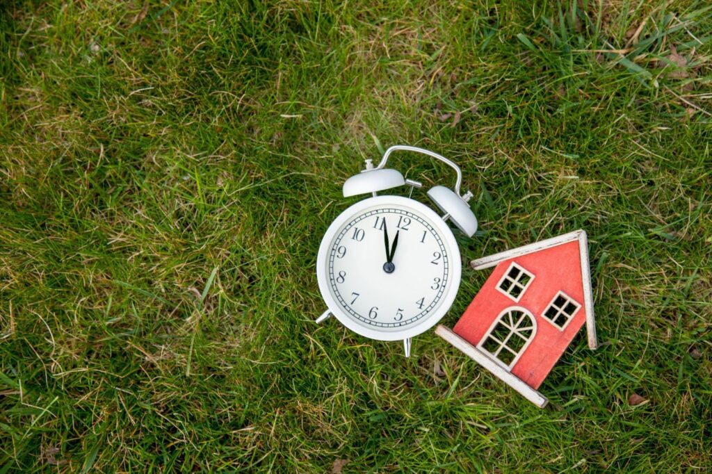 White classic alarm clock with bells and toy house