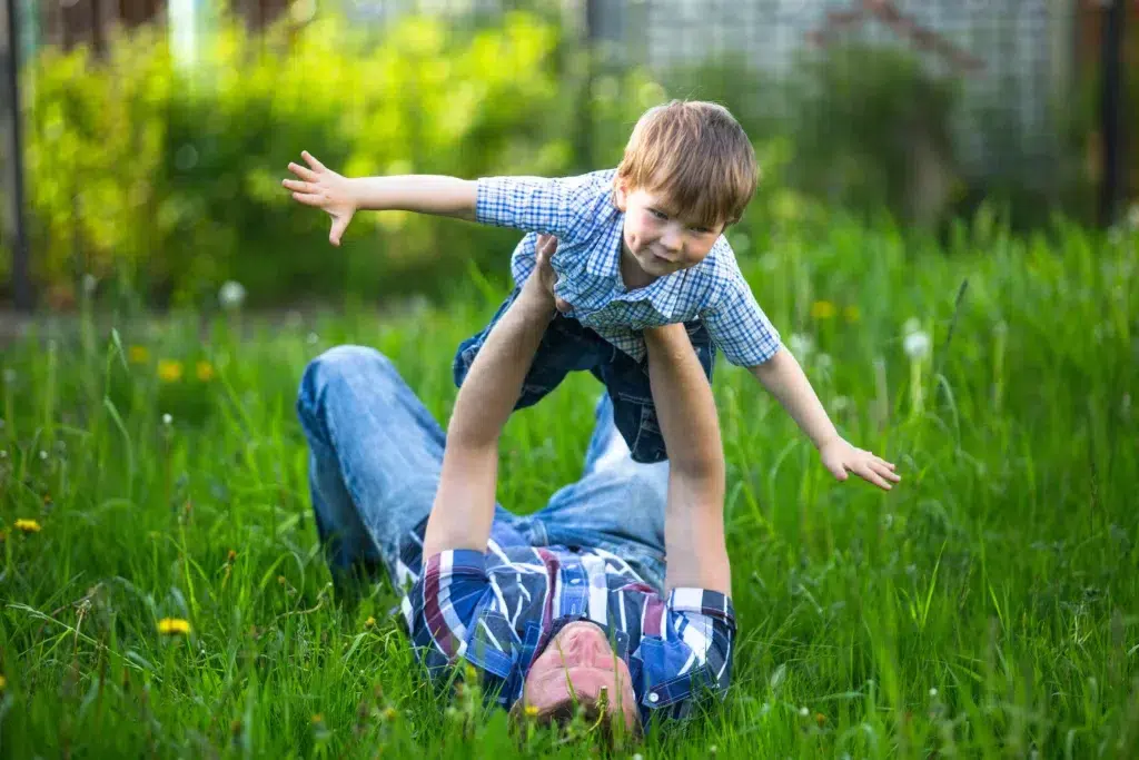 Guide on Father and son laying on the grass at backyard