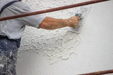 worker applying putty mortar on Wall