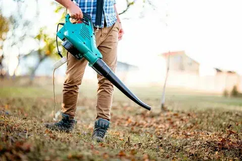 Describes Man operating a heavy duty leaf blower
