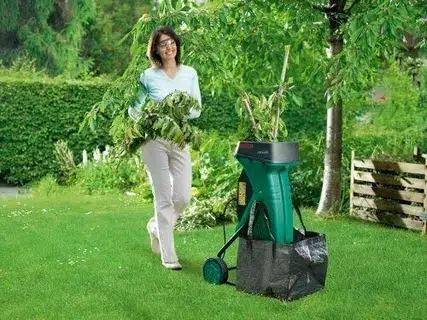 Woman using electric garden shredder