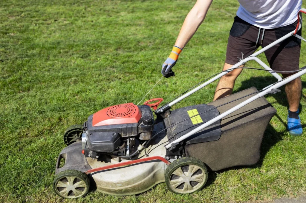 Gardener using a lawn mower in a lawn
